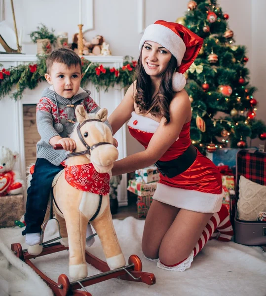 Güzel kadın Noel Baba Yardımcısı çocuk ile — Stok fotoğraf