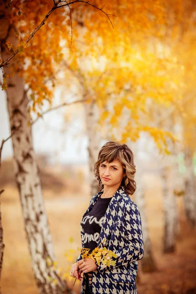 Jonge vrouw met herfstbladeren — Stockfoto