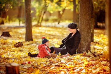Anne ve oğlu sonbahar parkında.