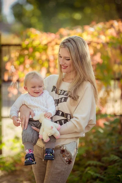 Moeder met babymeisje in herfst tuin — Stockfoto