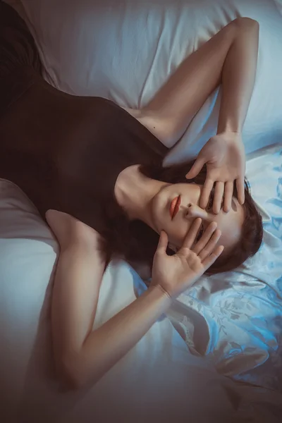 Красивая девушка лежит на кровати — стоковое фото