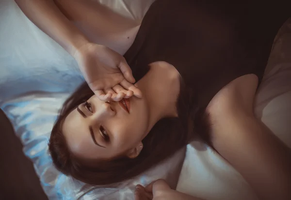 Schönes Mädchen auf dem Bett liegend — Stockfoto