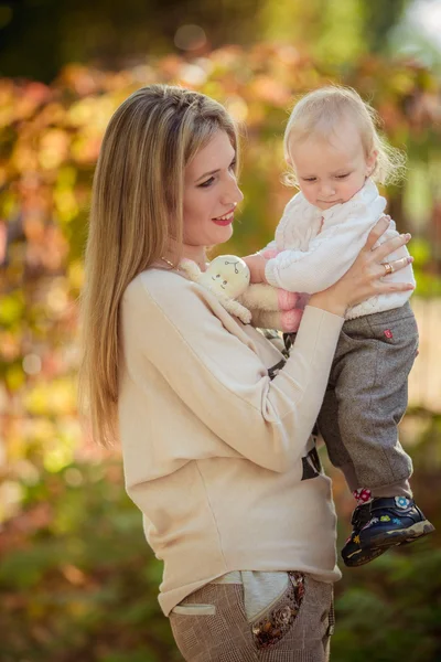 Moeder met babymeisje in herfst tuin — Stockfoto