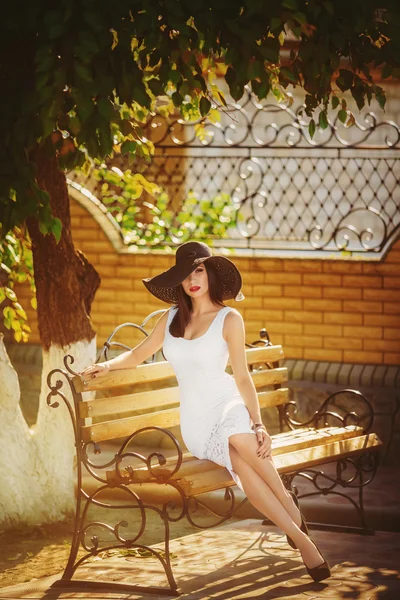 Красивая молодая женщина сидит на скамейке — стоковое фото