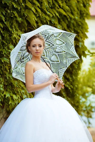 Sposa in abito bianco con ombrello in pizzo — Foto Stock