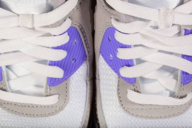 Yakın plan beyaz ayakkabı bağı ve açık gri spor ayakkabılar..