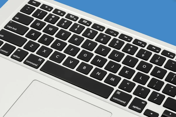 Apple MacBook Pro silver keyboard close up Mac on the blue background with free space for text