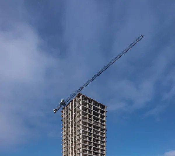 Byggarbetsplats med tornkran mot blå himmel — Stockfoto
