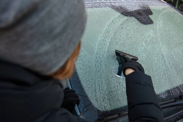 Clean car window from snow in winter time. Windshield cars cleaning