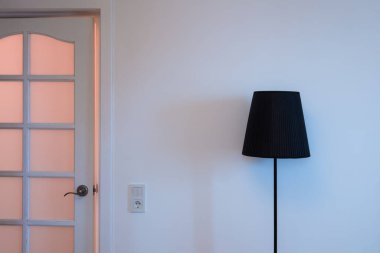 Üst ve üst taraftan modern bir çatı katı lambasının yakın plan fotoğrafı. Çıkışın yanındaki odada ışık anahtarı var.
