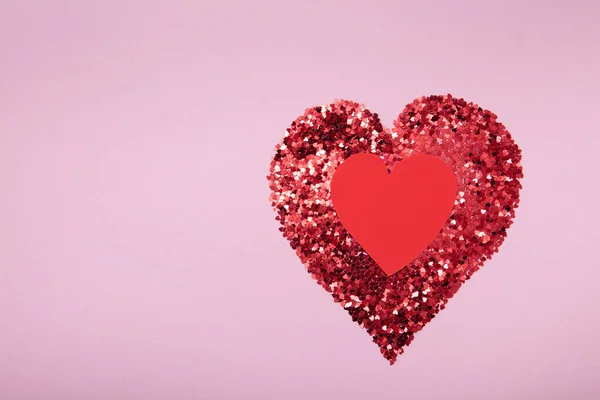 Forma de corazón hecha de purpurina roja y el segundo corazón hecho a mano de papel sobre fondo rosa. Concepto de amor. —  Fotos de Stock