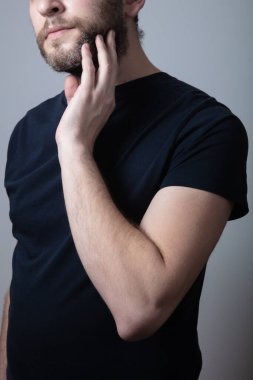 Gri sakallı bir adam yanaklarında kaşıntı ve kızarıklıktan muzdarip.