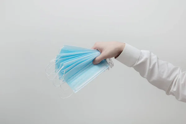 Erkeklerin elinde bir sürü tıbbi maske var.