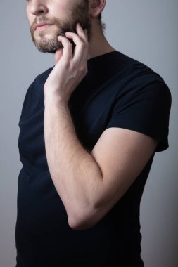 Gri sakallı bir adam yanaklarında kaşıntı ve kızarıklıktan muzdarip.