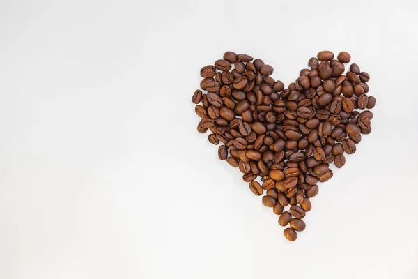 Кофе-бобы в форме сердца изолированы на белом фоне — стоковое фото