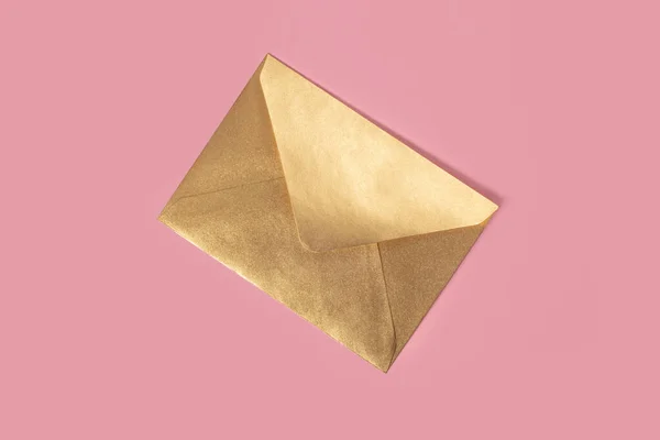 Envelope de papel dourado isolado sobre fundo rosa — Fotografia de Stock