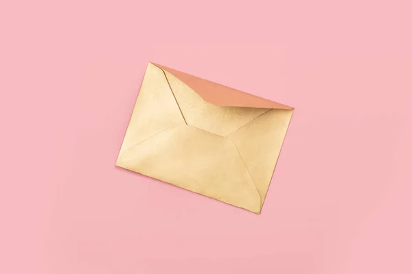 Envelope de papel dourado isolado sobre fundo rosa — Fotografia de Stock