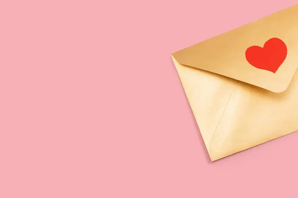 Envelope de papel dourado com coração vermelho isolado em fundo rosa — Fotografia de Stock