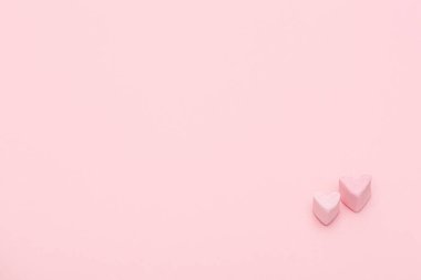 Pembe arka planda iki küçük tatlı kalp. Mutlu Sevgililer Günleri