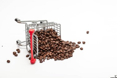 Beyaz arka planda kahve çekirdekleri olan bir alışveriş arabası.