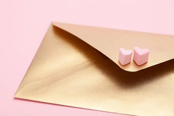 Plic de hârtie aurie cu două inimi din bezea izolată pe fundal roz — Fotografie, imagine de stoc