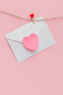 Elbise askısı, kırmızı kalp ve ipte aşk mektubu.