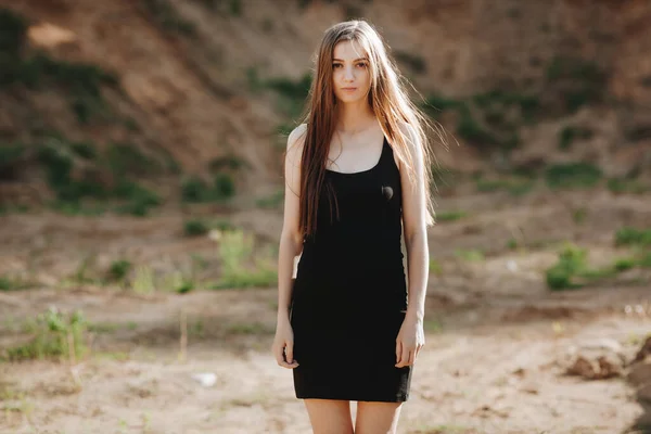 Portrait of a young beautiful woman in a black dress walks outdoor — Stock Photo, Image