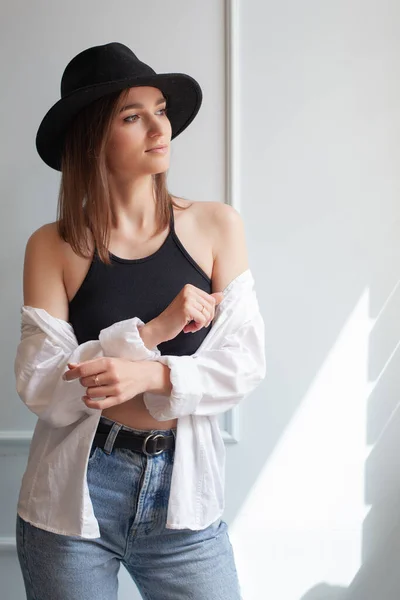カジュアルな夏服カタログのスタジオの白い背景に帽子をかぶった若いモデルの女性の肖像画 — ストック写真