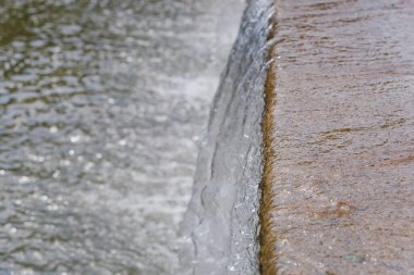 Geniş bir yapay şelaleye düşen temiz su manzarası. şelale arka planında donmuş su
