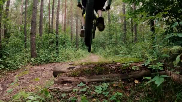 Cyklista skákání na odrazový můstek krok dolů mezera na horském kole zpět pohled ve zpomaleném filmu — Stock video
