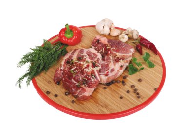 Yuvarlak bir tahtanın üzerinde çiğ et yatıyor.