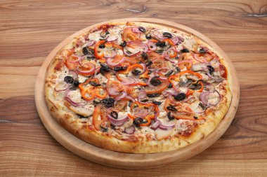 Tahta tabakta kesilmiş büyük bir pizza.