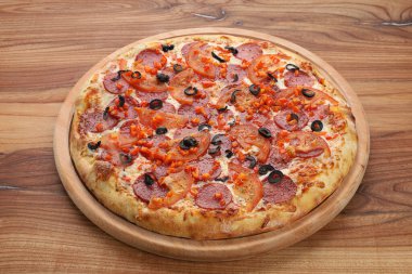 Tahta tabakta kesilmiş büyük bir pizza.