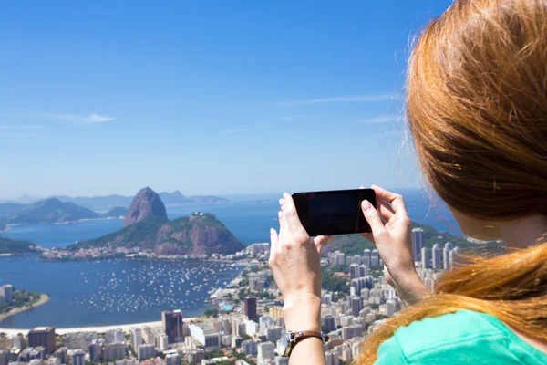Girl tourist takes a picture of Rio landscape with smartphone — Stock Photo, Image