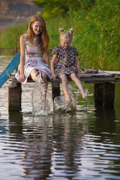 Mãe e filha sentadas no cais — Fotografia de Stock