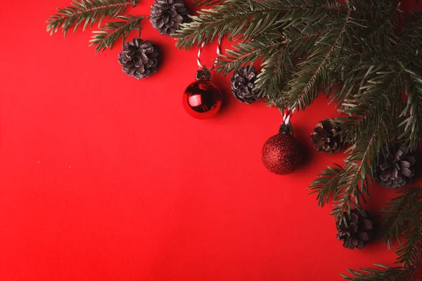 Χριστουγεννιάτικο Φόντο Χριστουγεννιάτικα Κλαδιά Μπάλες Και Κώνους Κόκκινο Φόντο — Φωτογραφία Αρχείου