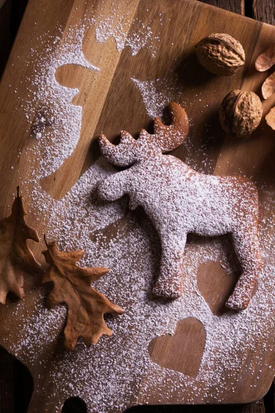 圣诞节仍然是生活 背景为木制桌子上的麋鹿状姜饼 坚果和橡木叶近B — 图库照片