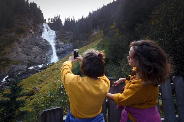 Dwie Szczęśliwe Dziewczyny Turyści Zrobić Zdjęcie Krimmler Wasserfalle Smartfonie Aktywny — Zdjęcie stockowe