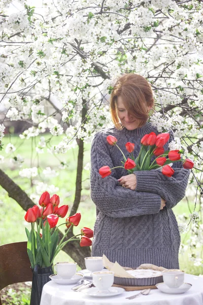 少女は手に赤いチューリップの花束を持っている — ストック写真