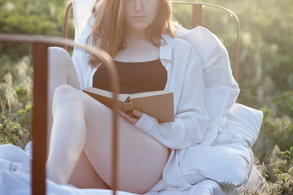 太陽の下で畑の間で本を読んでいる少女は — ストック写真