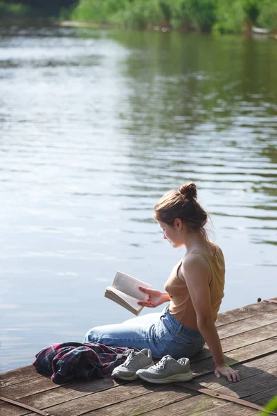 Kız Iskelede Oturuyor Bir Şeyler Okuyor — Stok fotoğraf