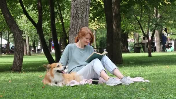 Jovem Mulher Lendo Livro Com Seu Cão Corgi Fluffy Sentado — Vídeo de Stock