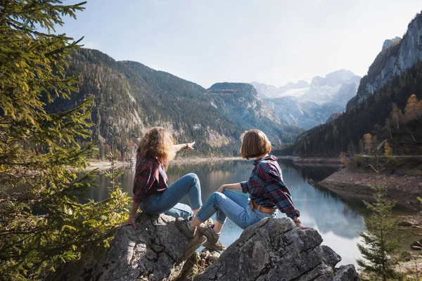 登山之旅 两个快乐的女孩在一座山湖畔 而另一个则在一座山后 — 图库照片