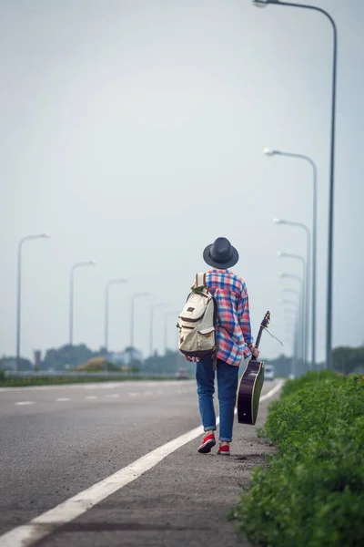 Молодая Девушка Гитарой Идет Дороге Автостопом — стоковое фото