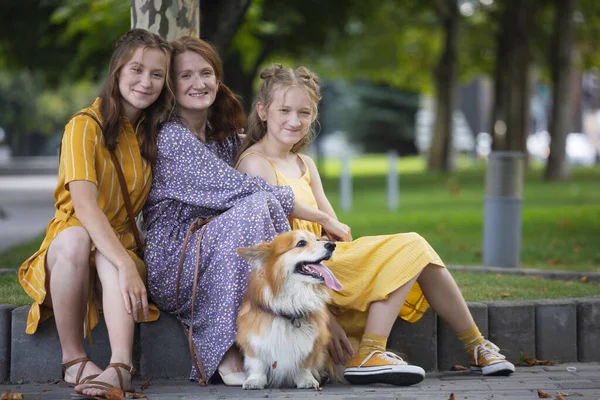 mom with daughters and dog corgi. dog in the famil