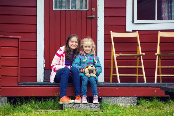 Syster flickor nära det röda huset — Stockfoto