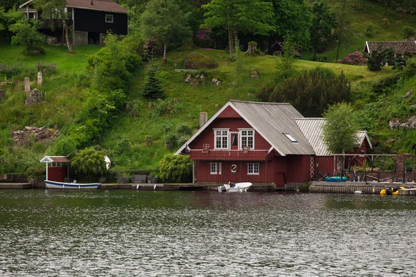 Casas vermelhas em uma costa de lago — Fotografia de Stock