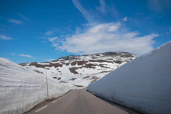 Paredes de neve em torno de uma estrada de montanha — Fotografia de Stock