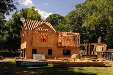 A residential home under construction mid framing and sheathing clipart