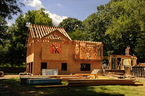 A residential home under construction mid framing and sheathing — Stock Photo, Image
